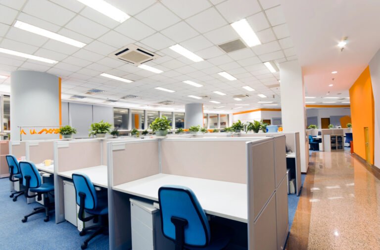 Bright Miami office interior with cubicles, blue chairs, plants, and shiny floors showcasing D-Force janitorial services